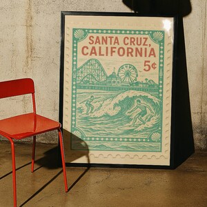 Może przedstawiać: Oprawiony plakat w stylu vintage z motywem Santa Cruz, Kalifornia. Plakat ma wz&oacute;r znaczka pocztowego z kolejką g&oacute;rską, diabelskim młynem i surferami. Paleta kolor&oacute;w obejmuje turkusowy, czerwony i kremowy.