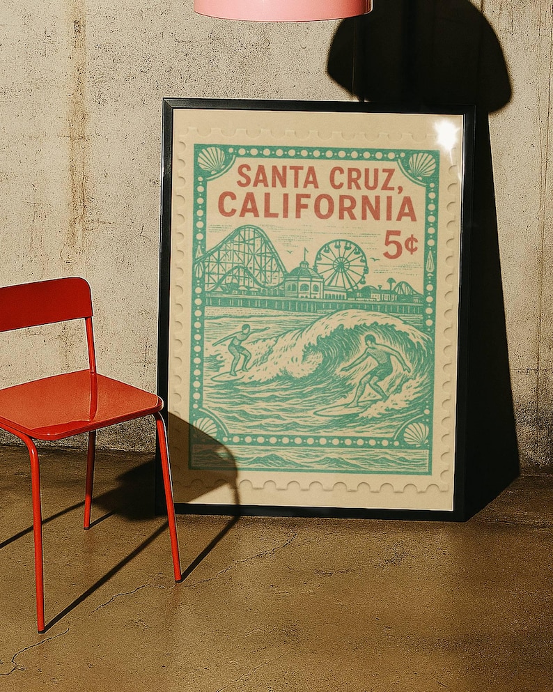 Może przedstawiać: Oprawiony plakat w stylu vintage z motywem Santa Cruz, Kalifornia. Plakat ma wz&oacute;r znaczka pocztowego z kolejką g&oacute;rską, diabelskim młynem i surferami. Paleta kolor&oacute;w obejmuje turkusowy, czerwony i kremowy.