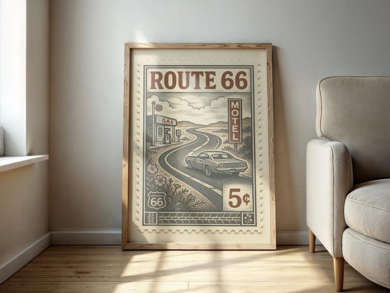 May include: Framed Route 66 art print. The artwork features a vintage car driving on a winding road, with a gas station and motel sign. The design is in shades of brown and beige, resembling a postage stamp.