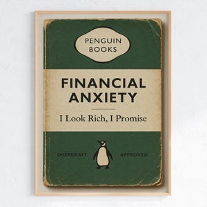 Könnte beinhalten: Gerahmter Druck eines Buchcovers von Penguin Books mit dem Titel "FINANCIAL ANXIETY" und dem Slogan "I Look Rich, I Promise". Das Cover ist grün und cremefarben mit einer Pinguin-Illustration. Die Wörter "OVERDRAFT" und "APPROVED" sind ebenfalls sichtbar.