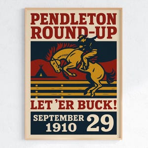 May include: A vintage-style poster with a tan frame. The poster features a cowboy riding a bucking bronco, with text that reads "Pendleton Round-Up" and "Let 'Er Buck!" The date "September 29, 1910" is also displayed.