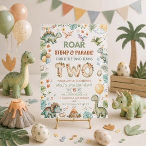 Puede incluir: Una tarjeta de invitación de cumpleaños rectangular con ilustraciones en acuarela de dinosaurios, hojas tropicales y un volcán. El texto dice: ROAR STOMP & PARADE! OUR LITTLE DINO TURNS TWO. PLEASE JOIN US TO CELEBRATE MILO'S 2ND BIRTHDAY! DEC 15 3PM THE CARTER RESIDENCE 10 PALM GROVE LANE, BRISBANE QLD RSVP TO EMMA 0412 345 678.