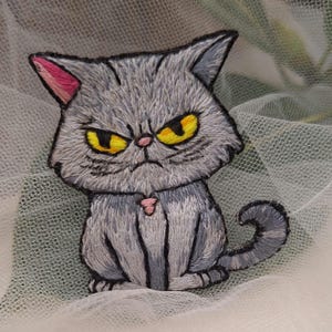 Broche "Chat Gris Grincheux" - Brodée à la main au point de satin, fils DMC, feutrine, support velours, épingle en acier. Léger et expressif !