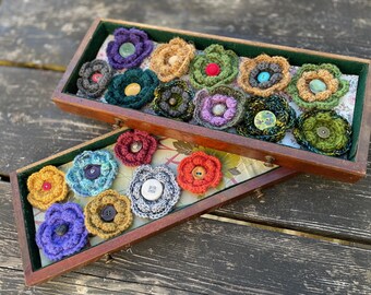Broszka od Campfire Crochet. Wykonana indywidualnie z przędzy z odzysku i guzików, każda jest wyjątkowa i jedyna w swoim rodzaju. Świetny sposób na uzupełnienie stylizacji!