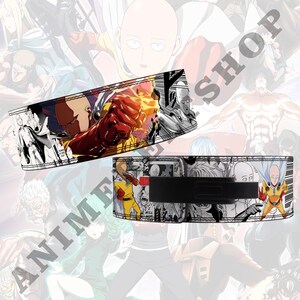 Pode incluir: Um cinto de levantamento de peso preto com fundo branco que apresenta uma colagem de personagens da s&eacute;rie de anime One Punch Man. O cinto tem uma fivela preta e um detalhe vermelho.