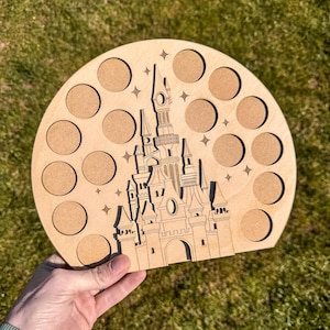 May include: A wooden cutout of a castle with a circular base. The castle has a detailed design and is surrounded by 12 circles. The circles are arranged in a circular pattern around the castle.