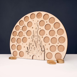 May include: A wooden, semi-circular display board with a castle cutout and numerous circular openings. The castle is intricately detailed. Small, round wooden tokens are at the base. The board is made of light-colored wood.