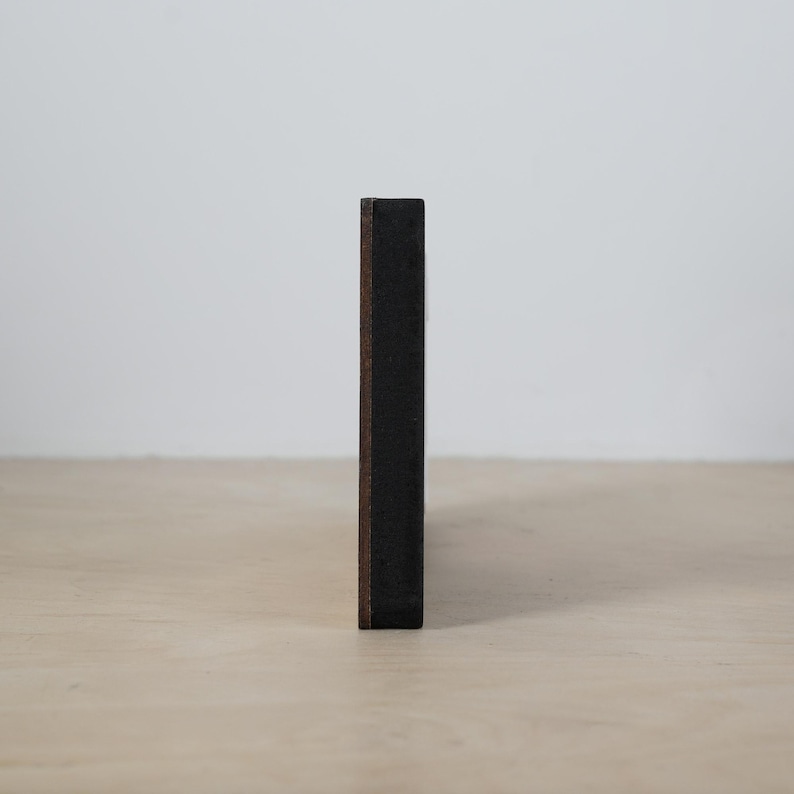 May include: A dark brown wooden frame with a black background.