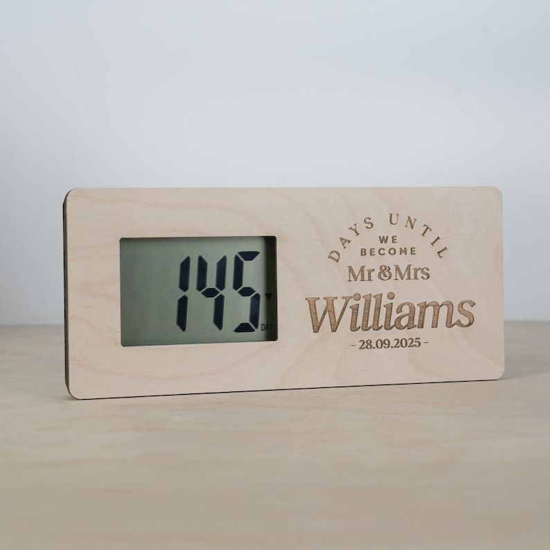 May include: A wooden countdown clock with a digital display showing "145" days until a wedding. The clock has a personalized message that reads "Days Until We Become Mr & Mrs Williams - 28.09.2025 - "