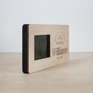May include: A wooden countdown clock with a digital display showing the number of days until a wedding. The clock is engraved with the text "Days Until We Become Mr & Mrs Williams - 28.09.2025".