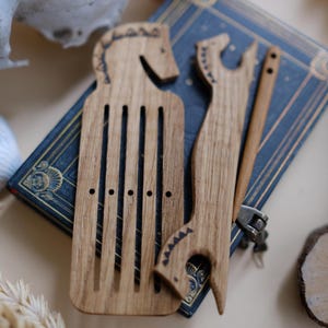 Peut inclure: Un métier à tisser en bois avec un motif de tête de cheval, utilisé pour tisser de petits projets. Le métier à tisser est en bois brun clair et comporte une série de trous pour enfiler le fil.