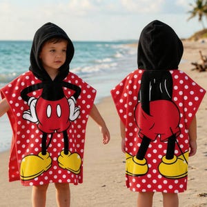 May include: Red and white polka dot hooded beach towel featuring a Mickey Mouse design. The towel has a black hood, and the Mickey Mouse graphic includes yellow shoes and white gloves. The towel is designed for children.