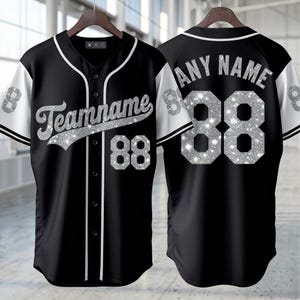 Könnte beinhalten: Ein schwarzes Baseballtrikot mit weißem Besatz und Ärmeln, das auf der Vorderseite den Schriftzug Teamname und die Nummer 88 in silbernem Glitzer zeigt. Die Rückseite zeigt den Text Any Name und die Nummer 88 im gleichen silbernen Glitzer.