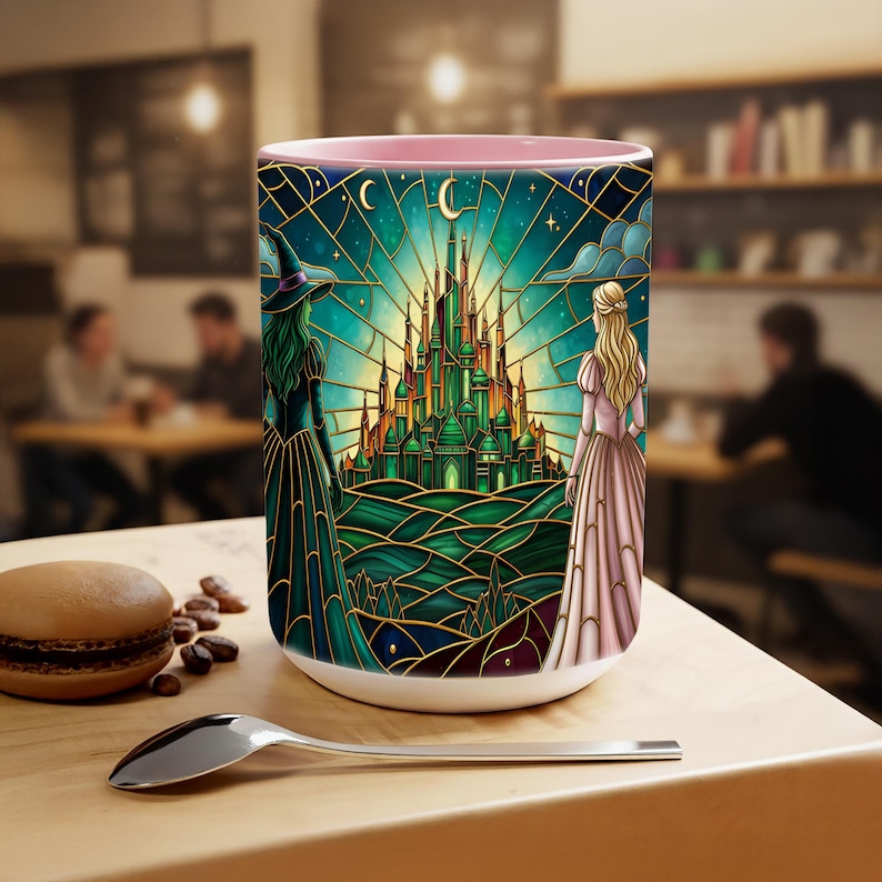 Puede incluir: Taza de cer&aacute;mica blanca con interior rosa, con un dise&ntilde;o de vidriera de un castillo verde, una bruja y una princesa. El dise&ntilde;o incluye una luna creciente y estrellas. La taza est&aacute; sobre una mesa de madera con una cuchara y un macaron.