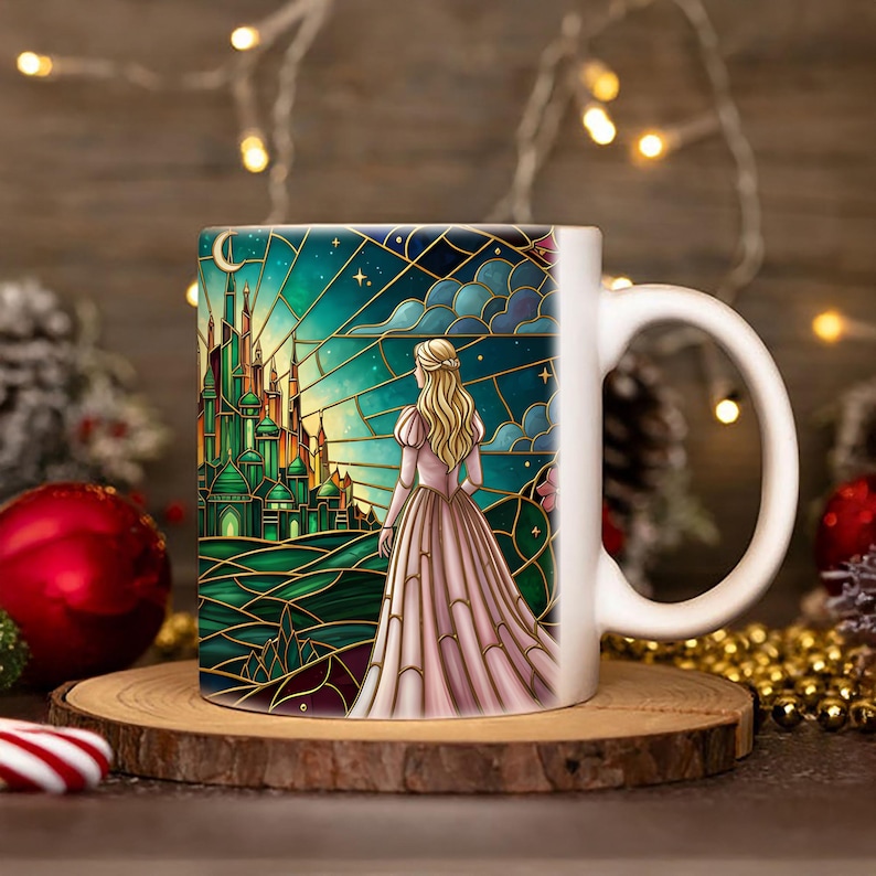 Puede incluir: Taza de cer&aacute;mica blanca con una ilustraci&oacute;n estilo vidriera de una mujer con un vestido rosa mirando un castillo verde bajo un cielo estrellado. La taza est&aacute; sobre un posavasos de madera, con decoraciones navide&ntilde;as en el fondo.
