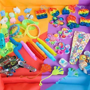 Colorful assortment of fidget toys including pop-its, squishy figures, slap bracelets, stretchy tubes, and sensory items on a bright background.