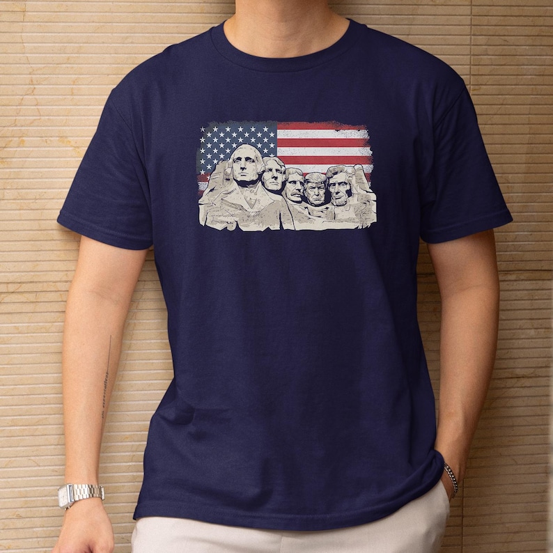 A navy blue t-shirt with a graphic design featuring the Statue of Liberty and George Washington on the front.