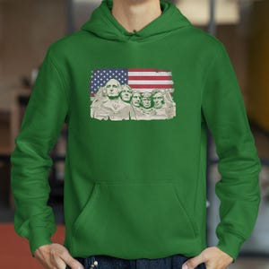 A person wearing a green hoodie with an American flag design featuring the Statue of Liberty.