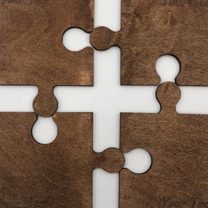 May include: Four brown wooden jigsaw pieces with rounded edges and a smooth finish. Each piece has the text "Your Text" engraved on it. The pieces fit together to form a square.