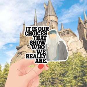 May include: A sticker with the quote "IT IS OUR CHOICES THAT SHOW WHO WE REALLY ARE." features an illustration of a wizard with a long white beard. The background shows a castle and a blue sky.