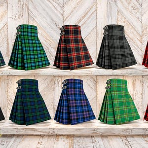 May include: A collection of ten pleated kilts displayed in two rows. Each kilt features a high-waisted design with two side buckle straps. The kilts are available in various plaid patterns including red, green, blue, black, and grey colour schemes.