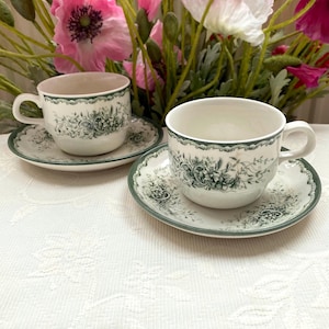 El precio incluye 1 taza y 1 platillo. Juego de taza y platillo decorativo. Rörstrand Suecia Grön Anna. Estampado floral verde oscuro. Presenta defectos, ver fotos.