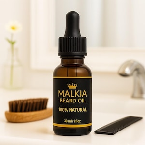 May include: A brown glass bottle of Malkia Beard Oil with a black label and dropper. The label includes a gold crown and the words "BEARD OIL" and "100% NATURAL". A wooden beard brush and comb are next to the bottle.