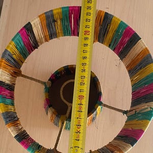 May include: A colorful lampshade made of woven strips of fabric. The lampshade is approximately 20 inches in diameter.
