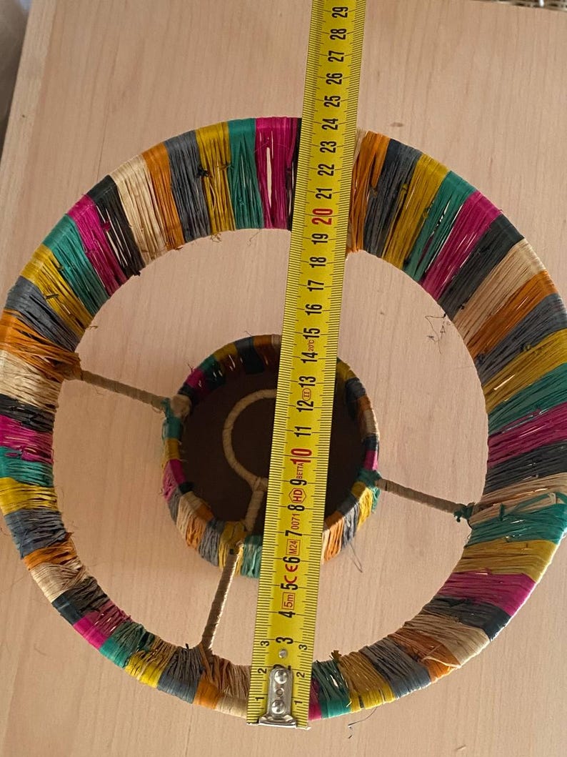 May include: A colorful lampshade made of woven strips of fabric. The lampshade is approximately 20 inches in diameter.