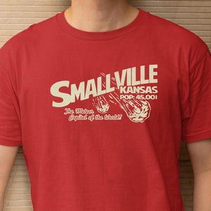 A red t-shirt with white text and graphics printed on it.
