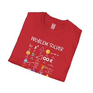 Puede incluir: Una camiseta roja con la frase "PROBLEM SOLVER" en blanco, junto con varios símbolos y ecuaciones matemáticas. La camiseta tiene cuello redondo y un pequeño diseño cerca del cuello.
