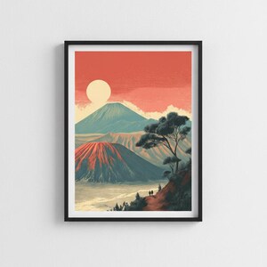 May include: A framed art print featuring a landscape illustration of a volcanic mountain range under a coral-colored sky with a pale sun. The scene includes a foreground ridge with a tree and two small figures, overlooking a valley and distant peaks.