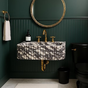 Könnte beinhalten: Ein Badezimmer mit einem Marmorwaschbecken, goldenen Armaturen und einer schwarzen Toilette. Das Waschbecken hat ein weißes und graues Muster. Ein goldgerahmter Spiegel hängt über dem Waschbecken. Die Wände sind dunkelgrün mit vertikalen Paneelen.