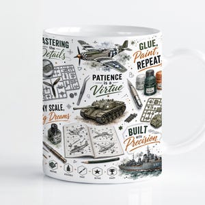May include: A white ceramic mug featuring a detailed graphic print of model building tools, a tank, a warplane, a naval ship, and an instruction manual. The text reads: Mastering the Details, Patience is a Virtue, Glue, Paint, Repeat, Any Scale, Big Dreams, and Built with Precision.