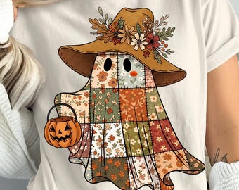 May include: A cream-colored t-shirt featuring a whimsical ghost design. The ghost is adorned with a patchwork quilt body, a brown hat decorated with flowers, and holds a jack-o'-lantern bucket. The design has a fall or Halloween theme.