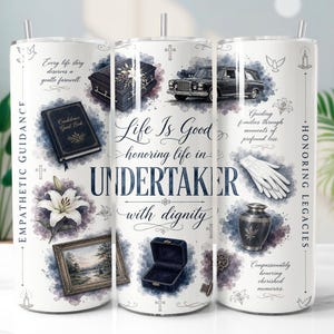 Puede incluir: Un vaso cilíndrico blanco con gráficos de temática funeraria que incluyen un coche fúnebre, ataúd, urna, libro de visitas, lirio blanco y guantes. El texto incluye "Life Is Good honoring life in UNDERTAKER with dignity" y "Empathetic Guidance".