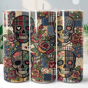 May include: Three stainless steel tumblers with a patchwork design featuring skull and rose graphics. The skulls have heart-shaped eyes and are surrounded by floral patterns in red, blue, and yellow. Each tumbler has a straw.