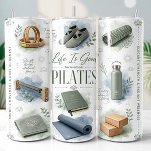 May include: A white cylindrical tumbler featuring a collage of Pilates-themed graphics including a yoga mat, foam roller, water bottle, exercise bands, and a towel. The text reads Life Is Good focused on PILATES, Mindful Movement & Core Alignment, and Elegant Strength & Radiant Wellness. The design includes soft blue watercolor accents and botanical illustrations.