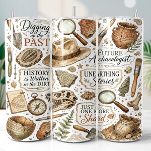 May include: A cylindrical tumbler featuring an archaeology-themed print with a fedora, magnifying glasses, compass, brushes, trowels, pottery shards, fossils, and text including Digging up the PAST, Future Archaeologist, and Just one more Shard.