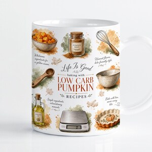 Può includere: Una tazza in ceramica bianca con illustrazioni ad acquerello di utensili e ingredienti da forno, tra cui una ciotola di cubetti di zucca, un barattolo di spezie, una frusta, un misurino, una bilancia digitale e una tortiera, con il testo Life Is Good baking with LOW CARB PUMPKIN RECIPES.