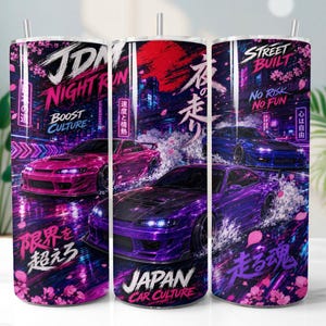 May include: A cylindrical tumbler featuring a vibrant JDM night run graphic with pink and purple sports cars, neon city lights, cherry blossoms, and Japanese text. The design includes phrases like JDM Night Run, Boost Culture, and Japan Car Culture.