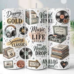 May include: A white cylindrical tumbler featuring a music-themed pattern with vinyl records, headphones, a record player, and stacks of albums. Text includes Digging for Gold, Music is Life, The Needle Drops, Vinyl Junkie, and Analog Soul.
