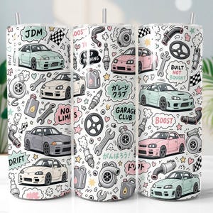 Może przedstawiać: Cylindryczny kubek z białym tłem i powtarzającym się wzorem przedstawiającym różne samochody sportowe JDM, turbosprężarki, klucze, świece zapłonowe i kanistry na olej. Projekt zawiera napisy takie jak JDM, Built Not Bought, No Limits, Boost oraz japońskie znaki.