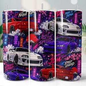 Op de afbeelding: Een cilindrische beker met een levendige grafische print van Japanse sportwagens in rood, wit en paars. Het ontwerp bevat kersenbloesems, neon stadslichten, een rode zon en tekst zoals Built for Speed, Street Legend en JDM.