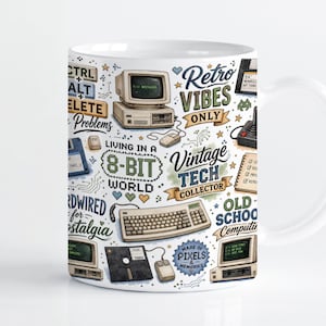 Puede incluir: Una taza de cerámica blanca con un estampado gráfico colorido de equipos informáticos retro, que incluye monitores, teclados, ratones y disquetes, intercalados con textos como Retro Vibes Only, Vintage Tech Collector y Living in an 8-Bit World.