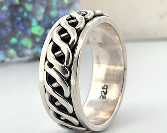 May include: A silver ring featuring a central spinning band with an intricate, continuous woven knot pattern. The interior of the band is smooth and clearly stamped with the hallmark 925, indicating sterling silver composition.