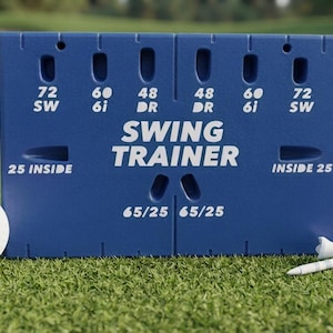 May include: A blue rectangular golf swing trainer aid with white text reading SWING TRAINER, 72 SW, 60 6i, 48 DR, 25 INSIDE, and 65/25. The device features various slots and markings, accompanied by a white golf ball and two white golf tees.