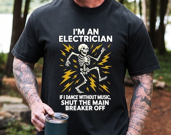 Puede incluir: Camiseta negra con el texto "I'M AN ELECTRICIAN" sobre un gráfico de un esqueleto bailando. Debajo del gráfico, el texto dice: "IF I DANCE WITHOUT MUSIC, SHUT THE MAIN BREAKER OFF".