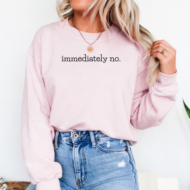 May include: A pink sweatshirt with the text "immediately no." printed on the front.