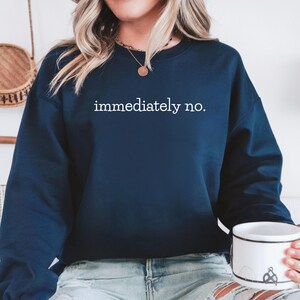 May include: A navy blue sweatshirt with the text "immediately no." printed in white on the front.